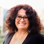 Frau mit braunen Locken und Brille