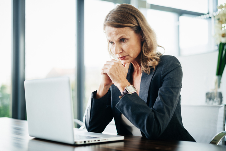 Managerin die konzentriert auf einen Laptop schaut