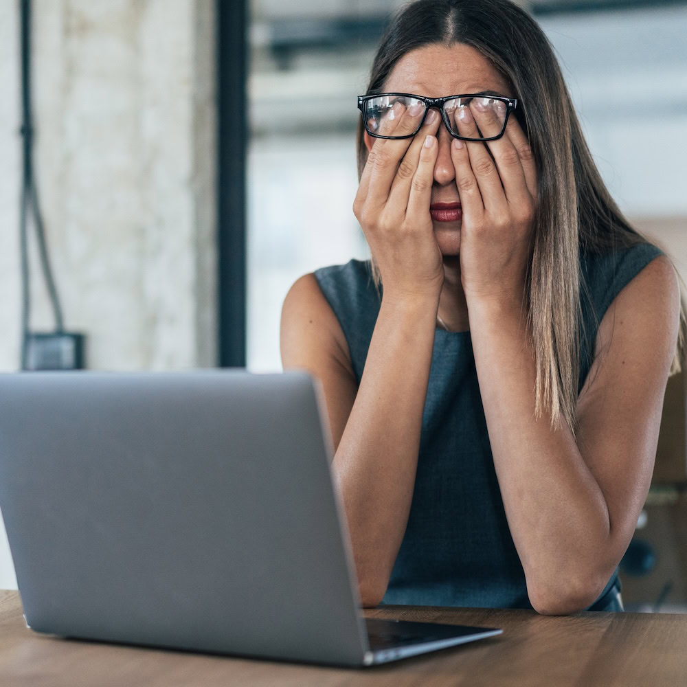 Eine Frau sitzt verzweifelt vor ihrem Computer.