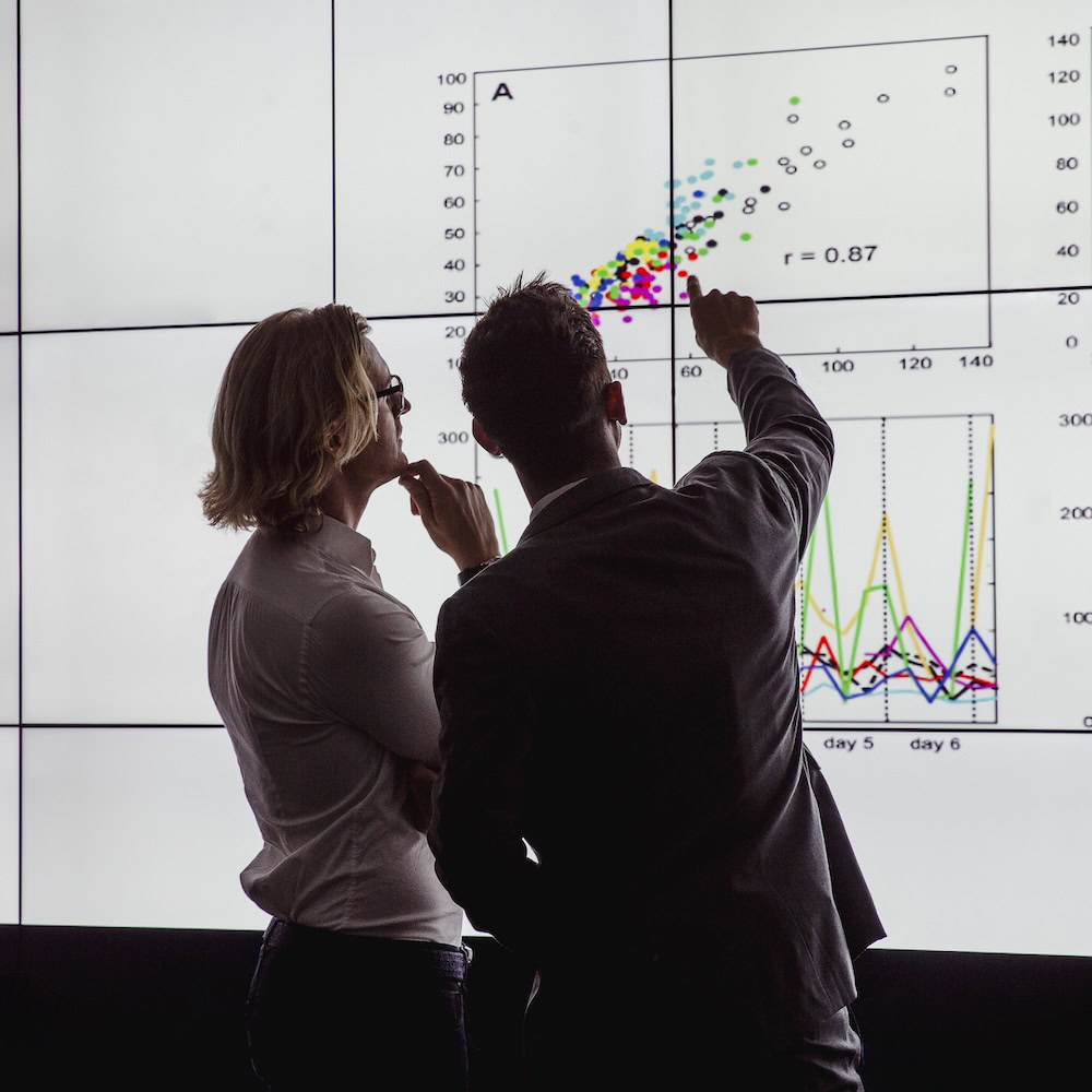 Zwei Männer werten Graphen an einem Bildschirm aus