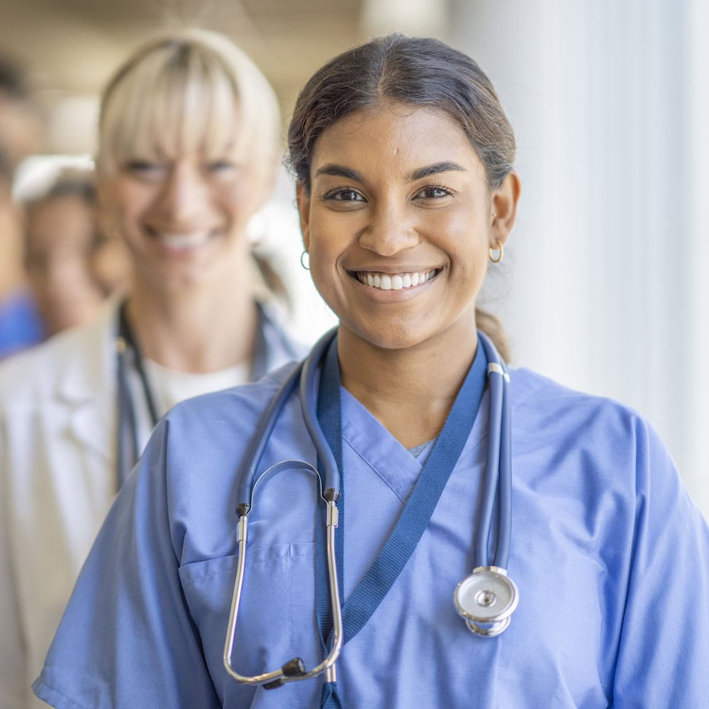 Zwei Ärztinnen lächeln in die Kamera