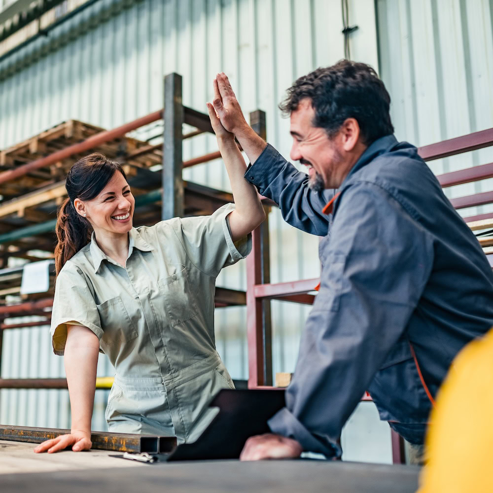 Zwei Fabrikarbeiter geben sich ein High Five