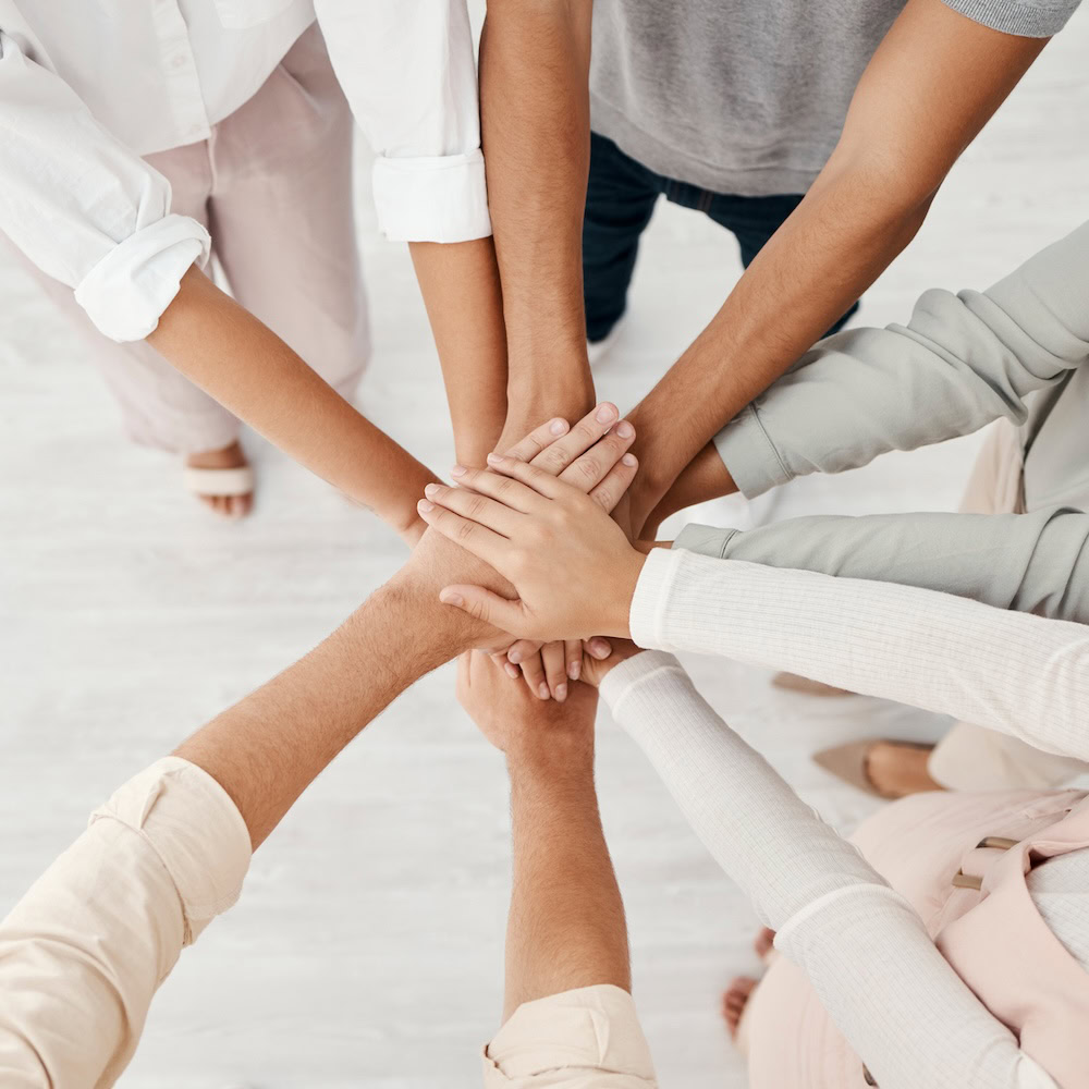 Mehrere Personen strecken die Hände zusammen