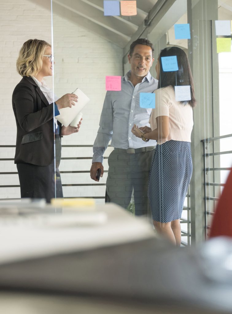 Drei Kolleginnen und Kollegen besprechen sich im Büro